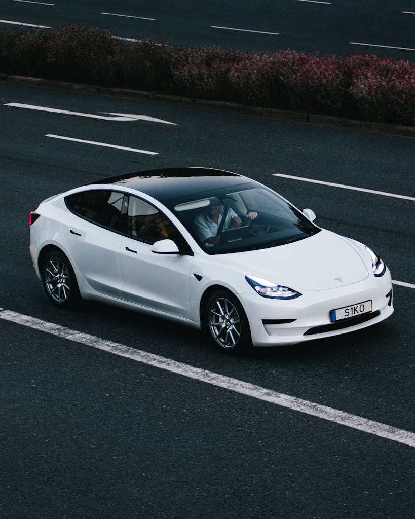 Tesla Model 3 driving on a highway in Osnabrück, Germany, showcasing modern electric vehicle design.